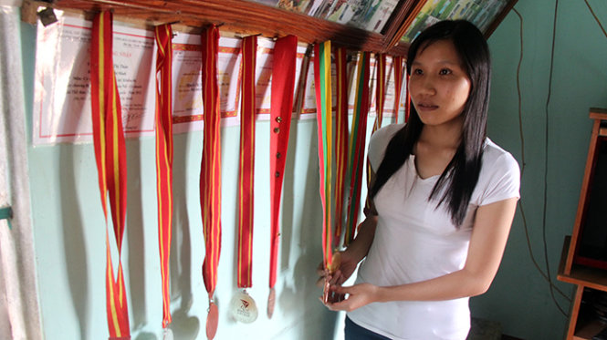 Thảo giới thiệu các bộ huy chương đã đạt được tại nhiều giải đấu - Ảnh: Tr.Tân