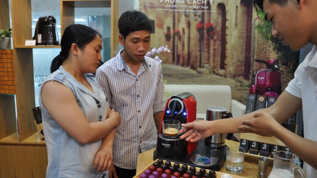 Nhân viên Trần Lê Nhật Hào (bìa phải) pha chế cà phê trên máy pha cà phê của hệ thống Sagaso Caffè Boutique - Ảnh: T.V.N.