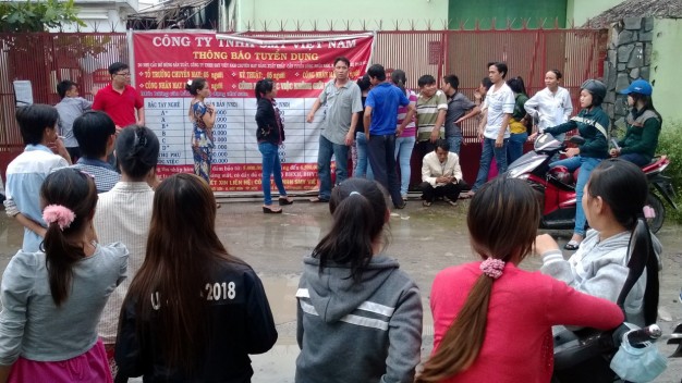Các công nhân Công ty TNHH SMY VN (H.Hóc Môn) tập trung trước cổng công ty để đòi tiền lương. Đến nay họ vẫn chưa nhận đủ số tiền lương tháng 7 và tháng 8 - 2014 - Ảnh: Q.P.