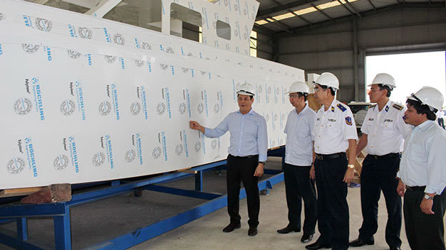 Thiếu tướng Nguyễn Văn Tương, chính ủy Bộ tư lệnh Cảnh sát biển Việt Nam (giữa), cùng đại diện báo Tuổi Trẻ kiểm tra tiến độ đóng xuồng cao tốc - Ảnh: P.Đ.