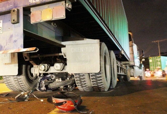 Chiếc xe máy bị nằm trọn dưới gầm xe container - Ảnh: Hải Hiếu