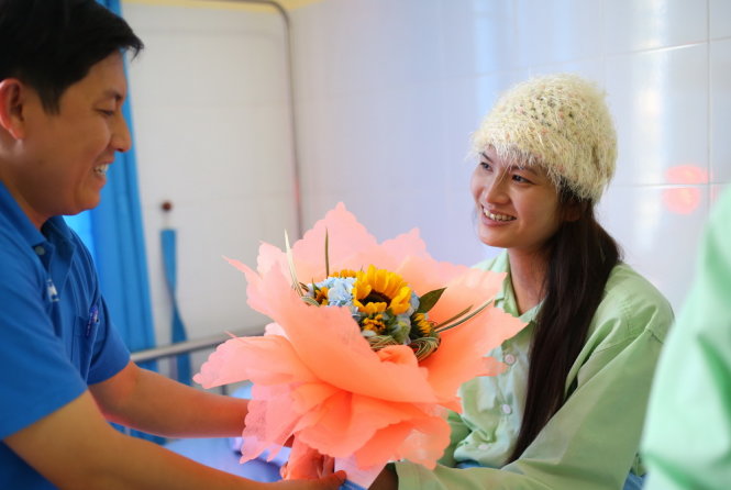 Đại diện Báo Tuổi Trẻ tặng hoa công nhân Đặng Thị Hồng Ngọc - Ảnh: Mai Vinh