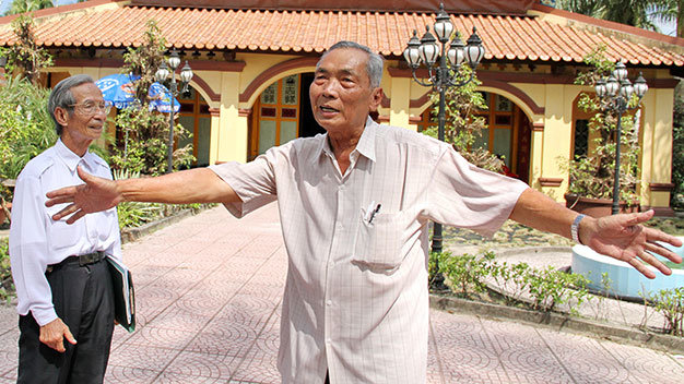 Ông Bé “rẫy” (phải) và ông Võ Hưng Thông kể chuyện lực lượng vũ trang tập luyện trước chùa Ông chuẩn bị cho Cách mạng Tháng Tám và toàn quốc kháng chiến - Ảnh: V.Tr.