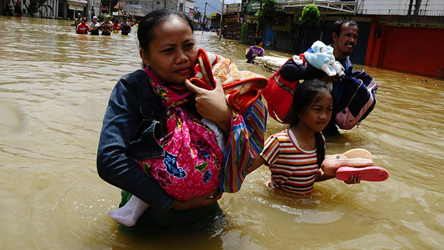 Người dân ôm đồ lội nước lụt đi sơ tán ở Tây Java, Indonesia - Ảnh: Reuters