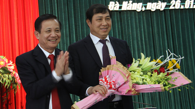 Ông Trần Thọ, bí thư Thành ủy (bên trái) tặng hoa chúc mừng ông Huỳnh Đức Thơ - Ảnh: Hữu Khá