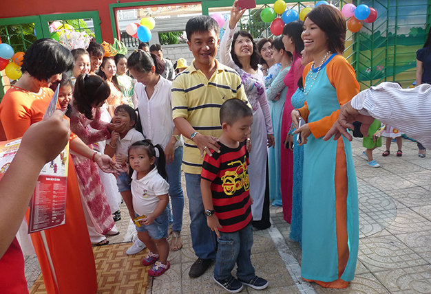 Nếu được chuẩn bị tốt về tâm lý, trẻ sẽ hào hứng, vui vẻ đến trường. Trong ảnh: Các cô giáo Trường mầm non Sơn Ca 11, Q.Phú Nhuận, TP.HCM đón học sinh ngay cổng trường - Ảnh: H.Hg.