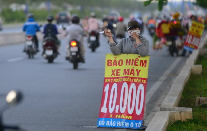 Bảng rao bán bảo hiểm xe máy 10 ngàn được bán trên Xa lộ Hà Nội, Q.2, TP.HCM trưa 6-5. Người bán cho biết đây là bảo hiểm hai người ngồi, hai người là 20 ngàn giảm còn 10 ngàn. Còn bảo hiểm xe máy là 66 ngàn nhưng giảm còn 55 ngàn, tổng cộng là 65. Người bán nói đây là bảo hiểm của quân đội. 10 ngàn chỉ là người ngồi- Ảnh: Quang Định