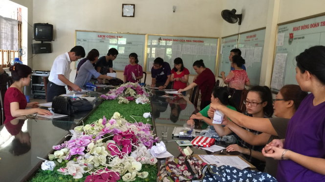 Phụ huynh và các em học sinh vội vàng làm lại hồ sơ xét tuyển thẳng mới trong thời tiết nắng nóng - ảnh: Thân Hoàng