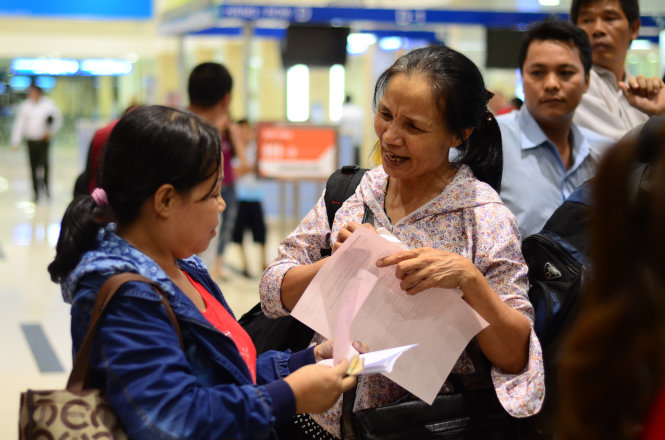 Chị Cao Thị Hiền (trái) và chị Phùng Thị Sánh (phải) bay chuyến bay lúc 11g30 nhưng đến 19g cùng ngày vẫn chưa bay được. Trong ảnh: hai chị đang làm thủ tục tại quầy làm thủ tục của Hãng hàng không VietJet Air lúc 19g tối 22-6 - Ảnh: Thanh Tùng