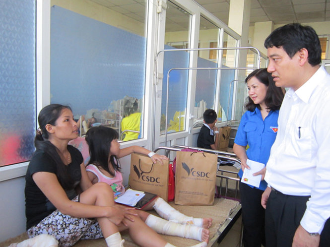 Anh Nguyễn Đắc Vinh- bí thư thứ nhất Trung ương Đoàn (bìa phải ảnh) thăm hỏi, trao quà cho các nạn nhân bị bỏng, hiện điều trị tại Bệnh viện Nhi Thanh Hóa chiều 7- 8- Ảnh Hà Đồng