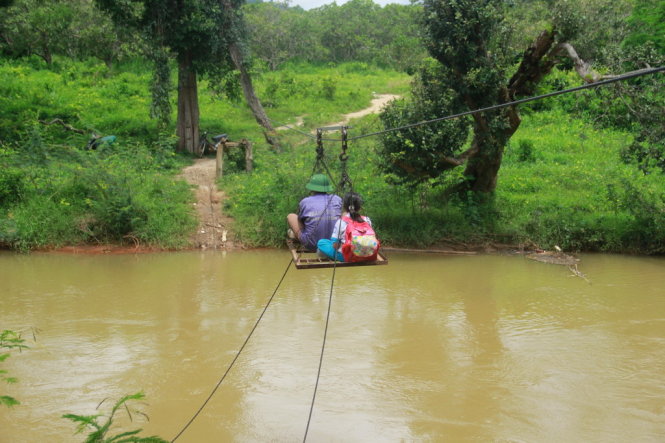 Bất chấp hiểm nguy, hàng ngày vẫn có hàng chục học sinh ở bên kia suối đu dây cáp để đến trường - Ảnh: B.D