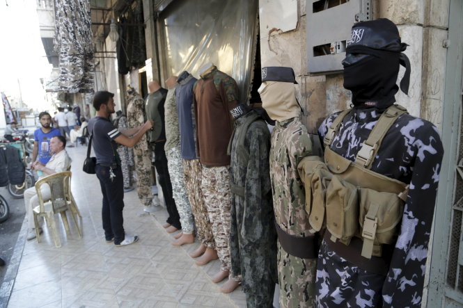 Lựa mua quần áo quân sự bày bán trên phố Maarat Al-Nouman, phía nam thành phố Idlib, Syria ngày 30-9 - Ảnh: Reuters