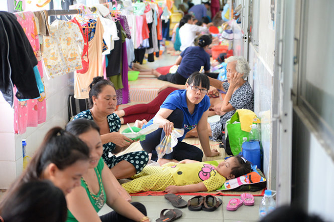Bệnh nhi nằm dưới nền gạch ngoài hành lang khoa hô hấp Bệnh viện Nhi Đồng 1 để điều trị bệnh - Ảnh: Hữu Khoa