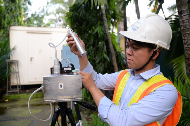 Cán bộ môi trường lấy mẫu không khí để phân tích các thông số ô nhiễm không khí tại trạm quan trắc Hồng Bàng (Q.5, TP.HCM) chiều 26-10, theo yêu cầu của Trung tâm quan trắc và phân tích môi trường TP.HCM - Ảnh: Hữu Khoa