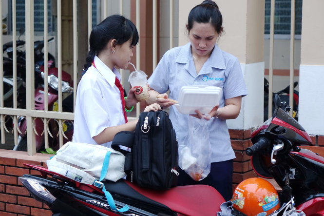 Sau giờ học chính khóa ở trường, nhiều học sinh tranh thủ ăn vội bánh mì, mì gói… để đến nơi học thêm cho kịp giờ - Ảnh: Như Hùng