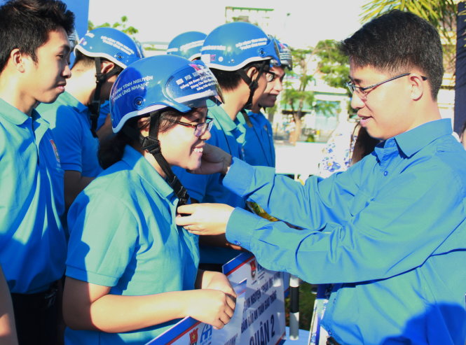 Phó bí thư Thành đoàn TP.HCM Phạm Hồng Sơn (phải) trao các dụng cụ cần thiết để các đội hình phản ứng nhanh làm nhiệm vụ - Ảnh: Q.L.
