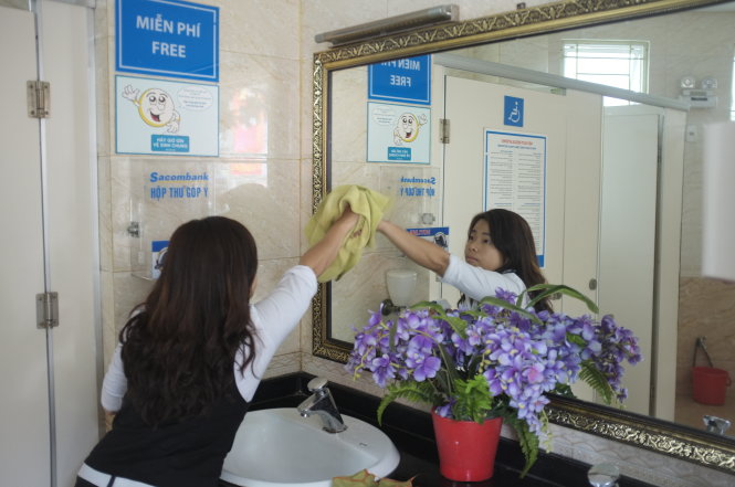 Nhân viên lau chùi giữ gìn sạch sẽ nhà vệ sinh công cộng trên đường Hai Bà Trưng, Q.1, TP.HCM - Ảnh: Châu Anh