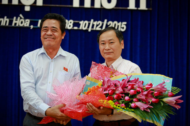 Ông Lê Thanh Quang, bí thư Tỉnh ủy Khánh Hòa (trái) trao hoa chúc mừng ông Nguyễn Đắc Tài trúng cử chức danh phó chủ tịch UBND tỉnh Khánh Hòa nhiệm kỳ 2011-2016 - Ảnh: Tiến Thành