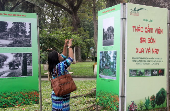 Một nữ du khách thích thú chụp lại những bức ảnh Thảo Cầm Viên xưa được trưng bày - Ảnh: Q.Khải