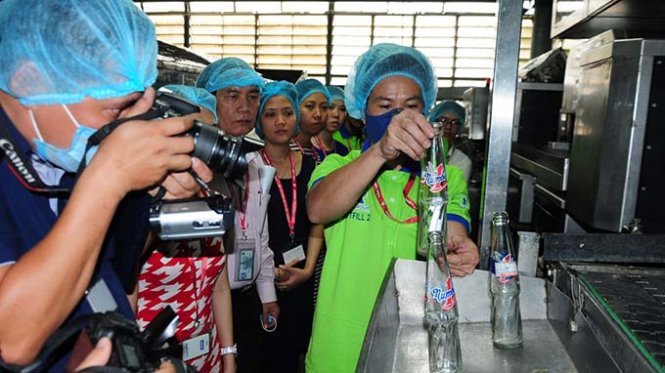 Nhân viên của Công ty Tân Hiệp Phát trình diễn quy trình phát hiện vật thể lạ trong chai nước tại cuộc làm việc với đoàn thanh tra Sở Y tế Bình Dương - Ảnh: Đức Trong