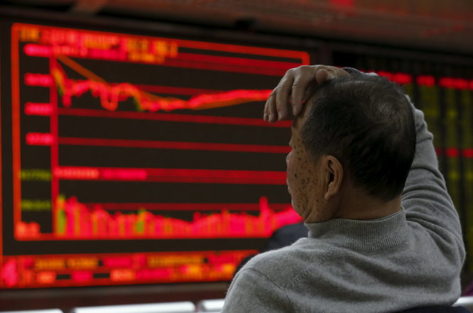 Nhà đầu tư lo lắng theo dõi giá chứng khoán tại một phòng giao dịch ở Bắc Kinh - Ảnh: Reuters