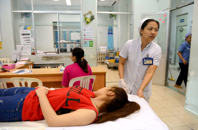 Dù làm rất tốt công việc nhưng nhiều viên chức vẫn đối mặt nguy cơ không hoàn thành nhiệm vụ vì không có công trình khoa học, đề án, đề tài hoặc sáng kiến. Trong ảnh: nữ hộ sinh Đặng Thị Hồng Nhung (khoa cấp cứu Bệnh viện Hùng Vương, TP.HCM) trong ca trực chiều 6-1 - Ảnh: Hữu Khoa