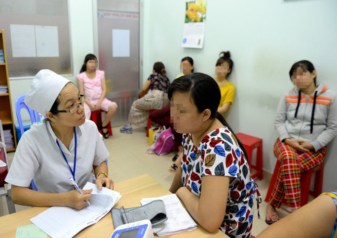 Nhiều bác sĩ cho rằng phải bận rộn khám và chữa bệnh nên không còn thời gian nghiên cứu khoa học. Trong ảnh: bác sĩ Bệnh viện Hùng Vương, TP.HCM khám cho một người dân - Ảnh: Hữu Khoa