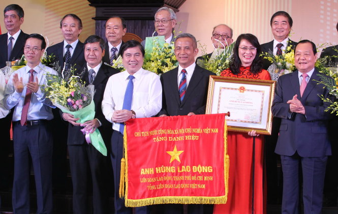 Ông Lê Thanh Hải - ủy viên Bộ Chính trị, chỉ đạo Đảng bộ TP.HCM
(bìa phải) - trao tặng danh hiệu Anh hùng lao động cho Liên đoàn Lao động TP.HCM - Ảnh: Vũ Thủy