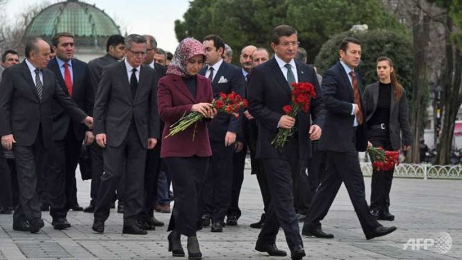 Thủ tướng Thổ Nhĩ Kỳ Ahmet Davutoglu và phu nhân cùng Bộ trưởng nội vụ Đức Thomas de Maiziere đến đặt hoa tưởng niệm các nạn nhân trong vụ đánh bom liều chết do IS thực hiện hôm 12-1 - Ảnh:AFP