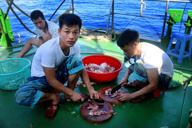 Binh nhất Trần Văn Tuấn (bìa trái) và binh nhì Quản Đức Tuấn sơ chế thức ăn trên tàu HQ-561 - Ảnh: N.Hiển