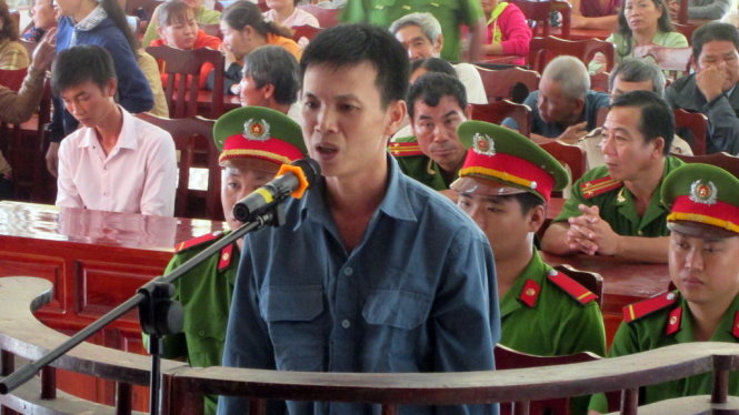 Bị cáo Nghĩa trước tòa và hàng trăm người dân tham dự phiên tòa - Ảnh: Thành Nhơn