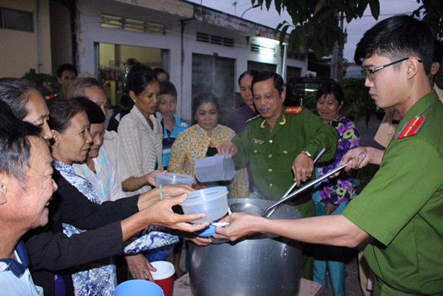 Đại tá Trần Quyết Liệt múc “cháo công an” cho bệnh nhân nghèo ở Mỹ Tú - Ảnh: Chí Quốc