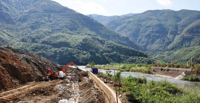 Công nhân thi công phần kè bảo vệ bãi bồi bị suối Pa Nậm Cúm đổi dòng xoáy sập ngay ngã ba đổ ra sông Nậm Na - Ảnh: Việt Dũng