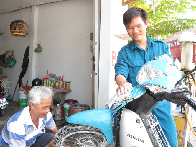 Tuấn Anh tranh thủ giúp cha mình rửa xe cho khách hàng khi ngày lên đường nhập ngũ đang đến gần - Ảnh: K.Anh