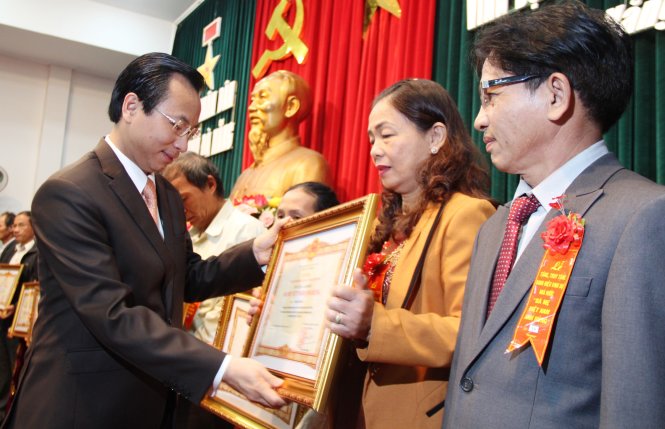 Ông Nguyễn Xuân Anh, bí thư Thành ủy Đà Nẵng, trao bằng phong tặng, truy tặng danh hiệu Bà mẹ Việt Nam anh hùng cho thân nhân các mẹ - Ảnh: P.Thành