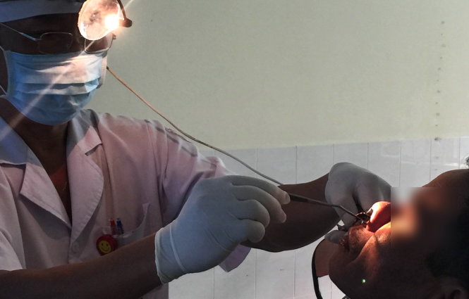 Bác sĩ gắp con đỉa còn sống trong mũi ông Pi Năng L. ra ngoài - Ảnh: NGUYỄN HỒNG QUANG