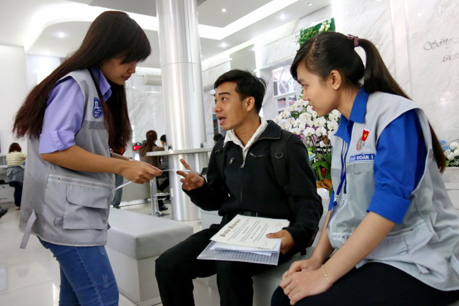 Lực lượng thanh niên hỗ trợ người dân tại UBND quận 1 sáng 1-3 - Ảnh: Ngọc Hiển