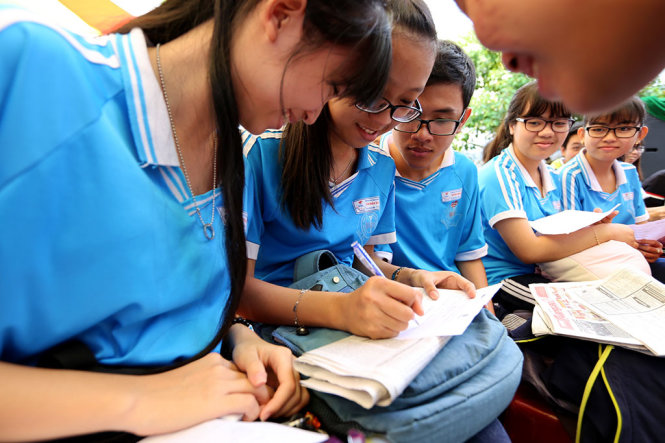 Học sinh Trường THPT Huỳnh Mẫn Đạt (Kiên Giang) trao đổi với nhau trước khi đặt câu hỏi cho ban tư vấn nhóm ngành tại buổi tư vấn sáng 6-3 - Ảnh: Như Hùng