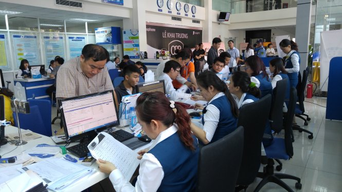 Bên trong trung tâm VNPT Vinaphone mở thêm nhiều quầy hỗ trợ thủ tục đăng ký để đáp ứng lượng khách hàng đông đảo ngày 7-3 - Ảnh: T.Trực