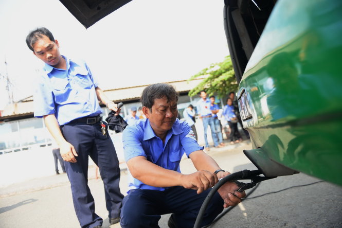 Đo khí thải xe buýt ngay ống khói - Ảnh: Hữu Khoa