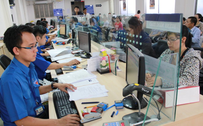 Các chuyên viên phòng đăng ký kinh doanh Sở Kế hoạch và đầu tư TP.HCM tiếp nhận và giải quyết hồ sơ, thủ tục cho người dân sáng 12-3 - Ảnh: Q.L.