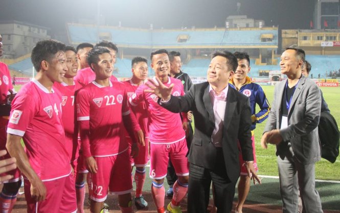 Chủ tịch CLB Nguyễn Giang Đông đứng khoanh tay phía sau, nhường cho “nhà tài trợ” Đỗ Quang Hiển huấn thị và thưởng cho cầu thủ CLB Hà Nội sau trận thắng Đà Nẵng - Ảnh: Ngọc Duy