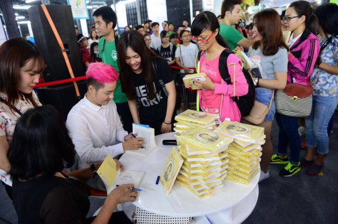 Ca sĩ Thanh Duy Idol ký tặng sách “Lỗi ở yêu thương về nhà với mẹ” tại Hội sách TP.HCM tối 21-3 - Ảnh: Quang Định