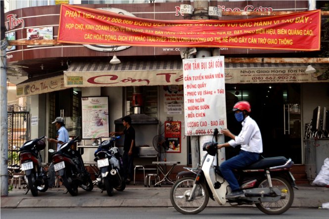 Một tấm băngrôn treo xộc xệch trên đường D2 (Q.Bình Thạnh, TP.HCM), rất khó để có thể đọc được toàn bộ những dòng chữ ghi trên đó - Ảnh: Duyên Phan