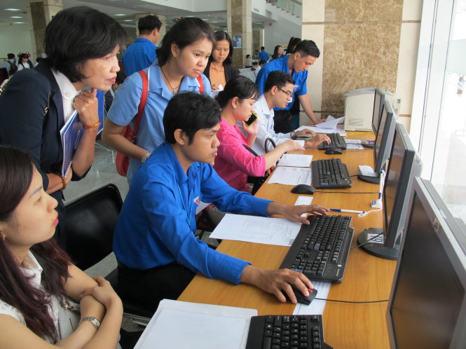 Nhân viên Cục Thuế TP.HCM hướng dẫn người nộp thuế điền tờ khai trên máy - Ảnh: A.H.