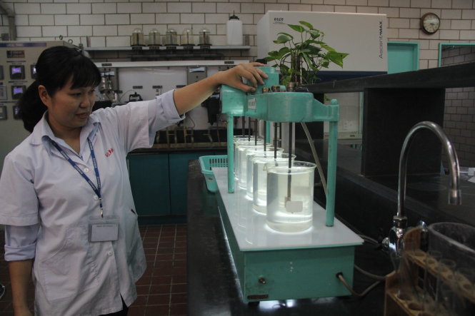 Nhân viên Nhà máy nước Thủ Đức kiểm tra chất lượng nước sau khi xử lý của nhà máy - Ảnh: Quang Khải