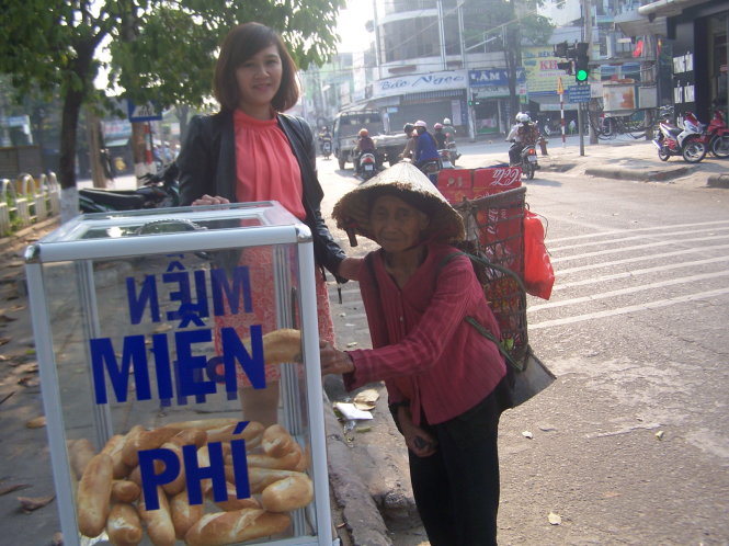 Cô giáo Lan bên tủ bánh mì miễn phí - Ảnh: T.T.Nhi