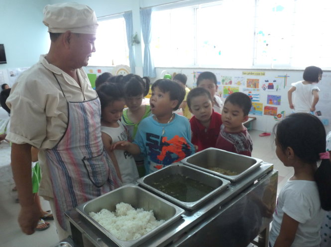 Ở Trường mầm non Lê Thị Riêng, Q.1, TP.HCM học sinh được giáo dục chào bác đầu bếp, bác bảo vệ. Trong ảnh: khi bác Phạm Văn Định - cấp dưỡng của trường - đẩy xe cơm xuống các lớp học, học sinh chạy ùa ra chào bác - Ảnh: H.HG.
