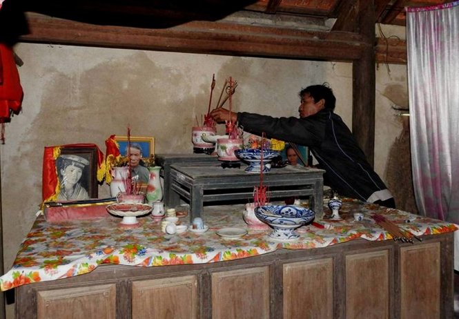 Bàn thờ của liệt sĩ Trần Văn Quyết mấy chục năm qua được đặt tạm trên chiếc sập đựng lúa - Ảnh: Q.Nam