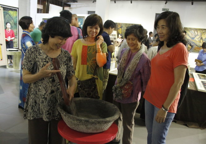 Khách tham quan tìm hiểu về các kỹ thuật chế tác tranh sơn mài truyền thống, sơn cánh dán và sơn then được trưng bày tại Trung tâm giao lưu văn hóa phố cổ Hà Nội. ảnh Đức Triết